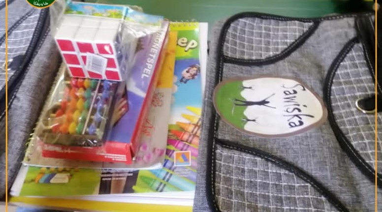 توزيع حقائب مع محتوياتها على الأطفال